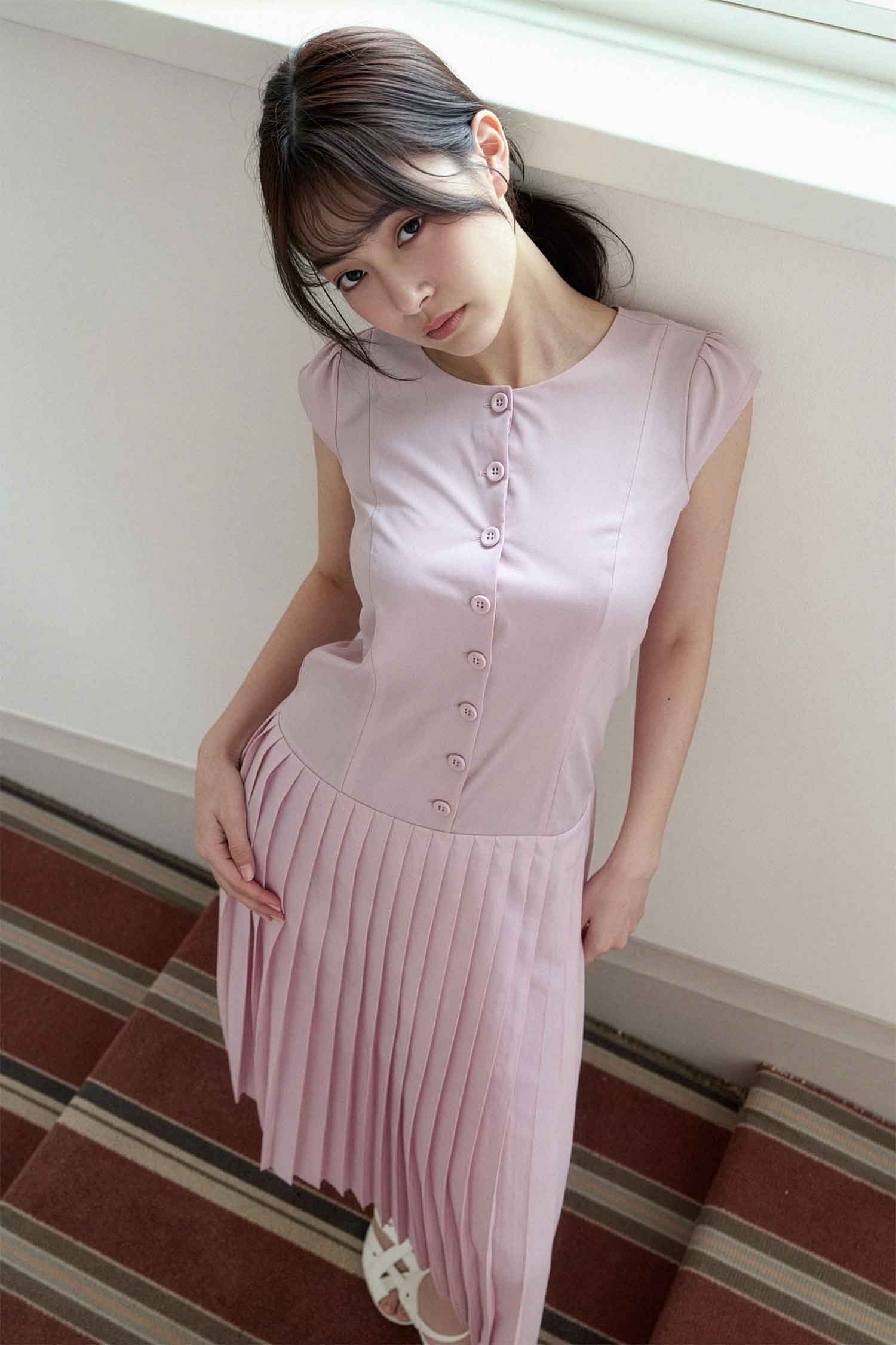 포토그래퍼 김준형이 캡처원 워크플로우로 기획 및 촬영한 여성 패션 룩북 화보로, 줄무늬 카펫이 깔린 실내 계단과 화이트 벽 배경의 하이앵글 구도에서 단추 디테일의 인디핑크 플리츠 원피스와 화이트 샌들을 착용하고 고개를 들어 카메라를 응시하는 여성 모델의 포트폴리오 사진 (phjun.co.kr)